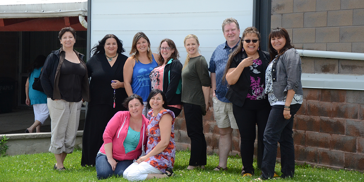 Jane Manning (back row, far left) and Lisa Gibson (back row, fifth from left) pose outside Antler River Elementary school with their MPEd in Aboriginal Education classmates.